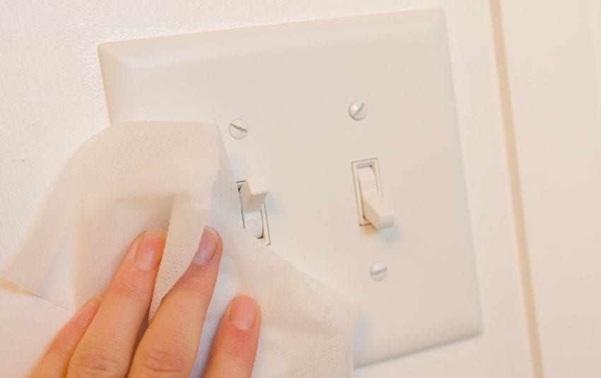 disinfecting and cleaning light switches to help prevent coronavirus covid-19