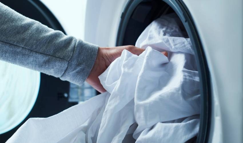 How to Clean Your Home After Being Sick Fresh bed linens ready after washing post-illness laundry