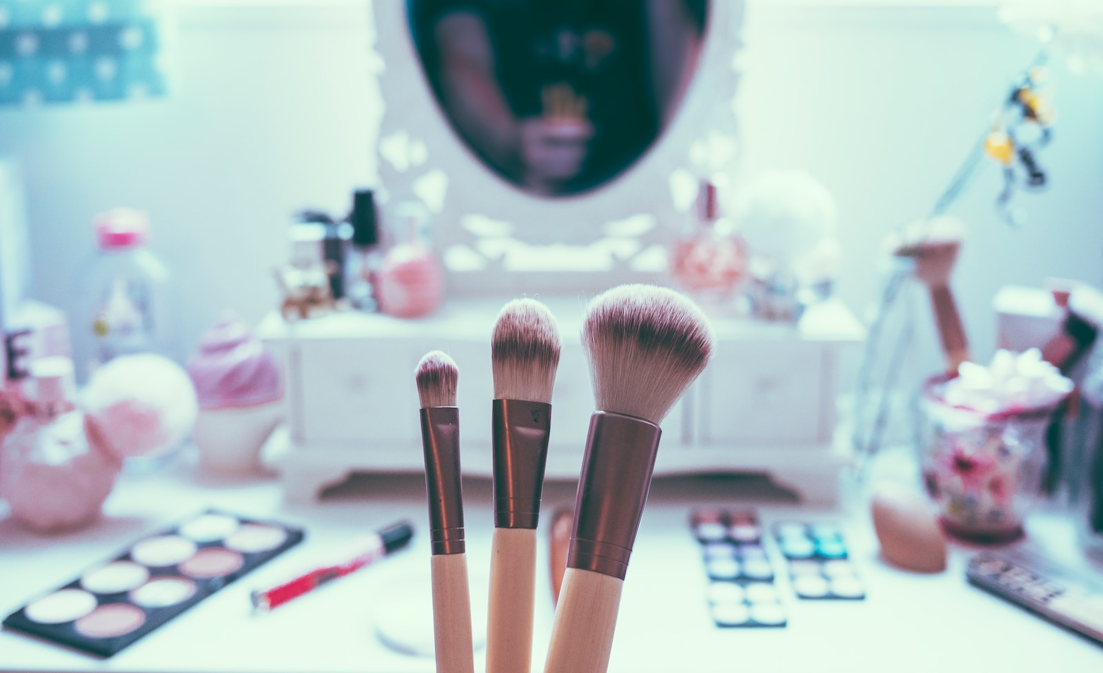 macro shot of three brown makeup brushes